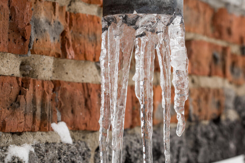 Natural icicles hanging on the pipe, the concept of winter Журналист
