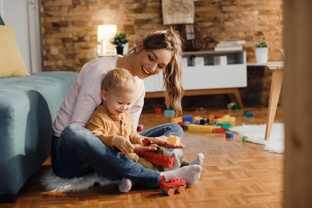 Happy m other and son having fun while playing on the floor at home. Журналист