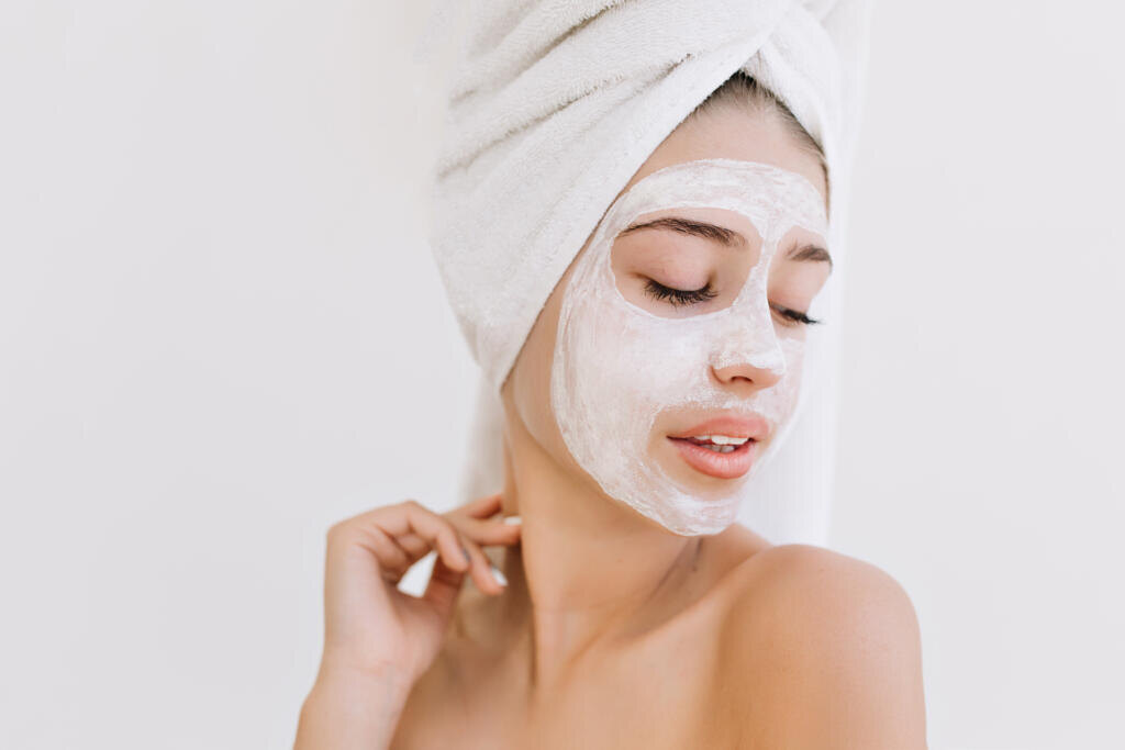Portrait of beautiful young woman with towels after take bath make cosmetic mask on her face. Rejuvenation, cosmetology, hydration and care face. Clean and perfect skin. Healthy body.White background Журналист