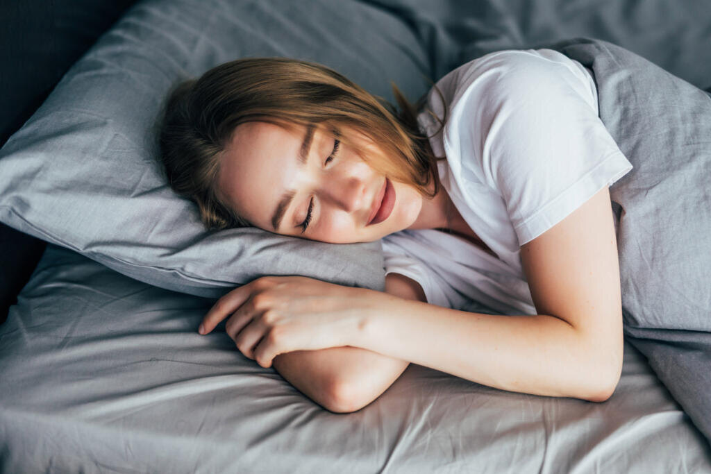 Woman sleeping. Beautiful young smiling woman sleeping in bed Журналист
