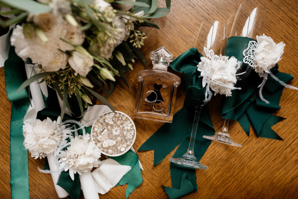 Wedding rings lie on the perfumes near other decor Журналист