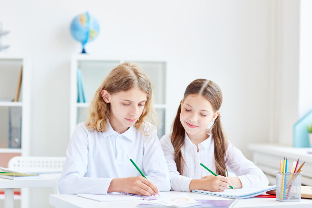 Small group of schoolmates working in team at lesson Журналист