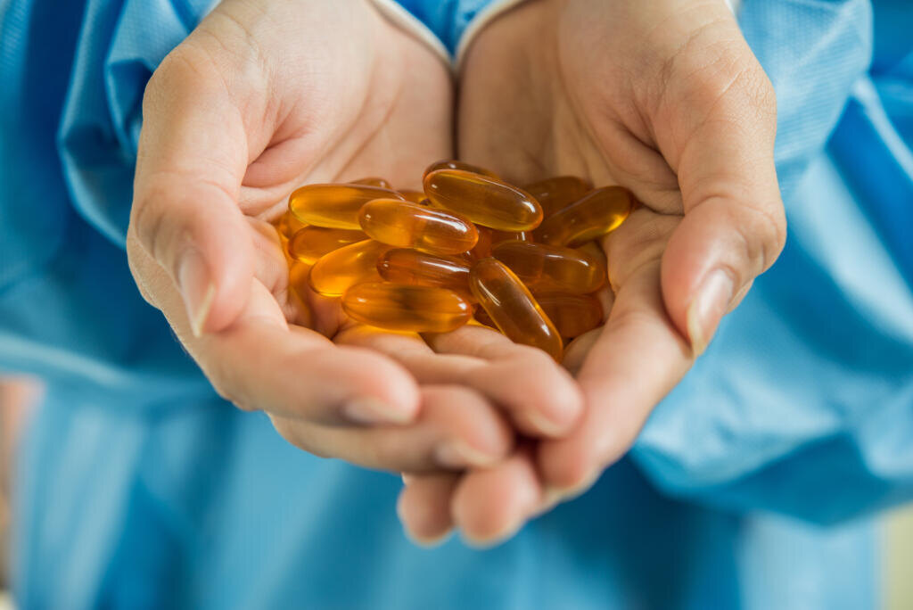 Woman's hand pours the medicine pills out of the bottle Журналист
