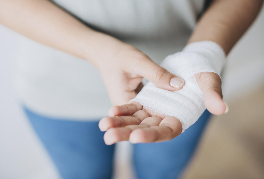 Woman with gauze bandage wrapped around her hand Журналист