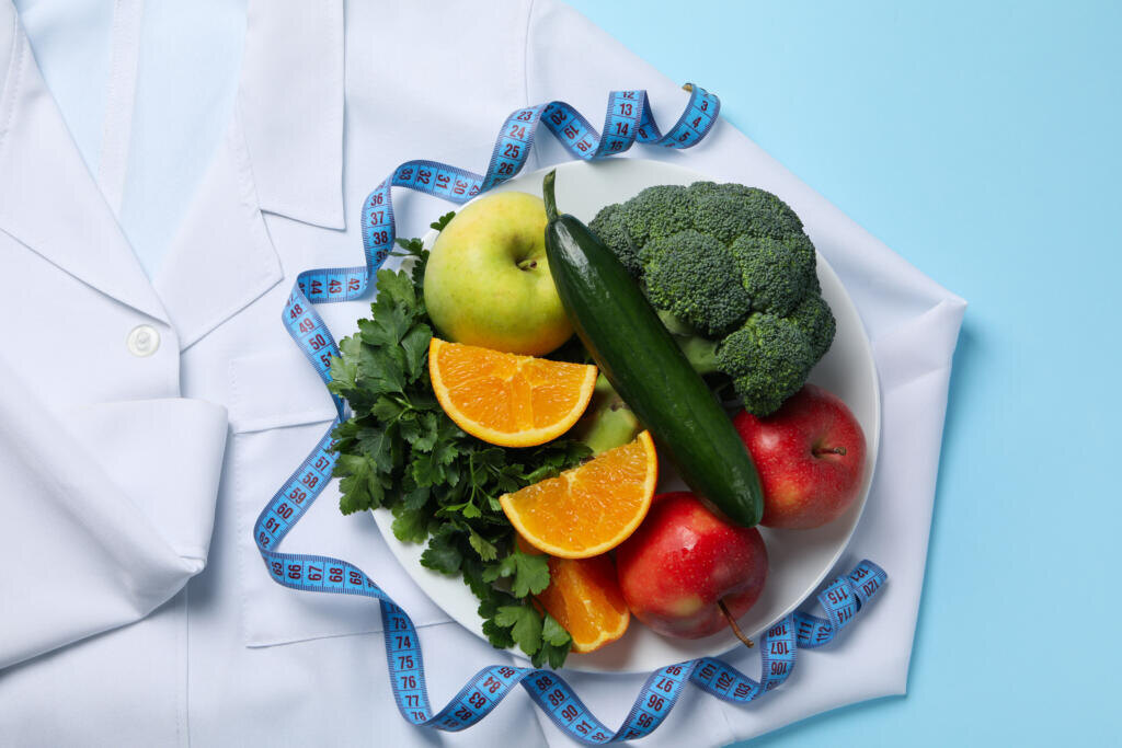 Doctors coat, healthy food and measuring tape on blue background — weight loss Журналист